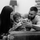 a man, woman and child sitting on a couch