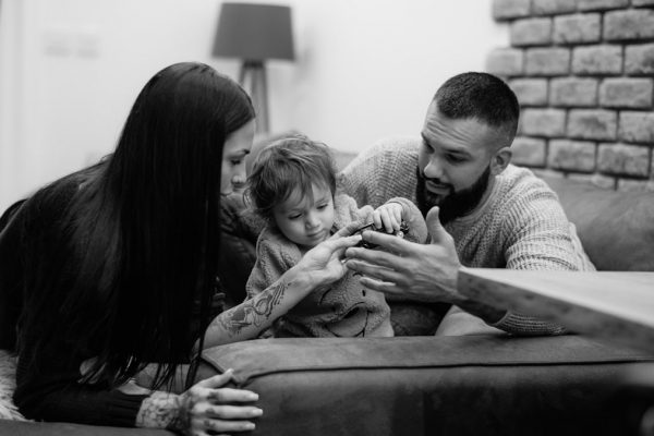 a man, woman and child sitting on a couch