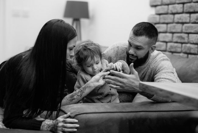 a man, woman and child sitting on a couch