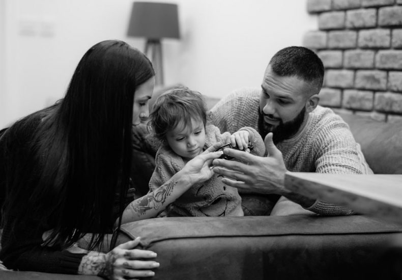 a man, woman and child sitting on a couch